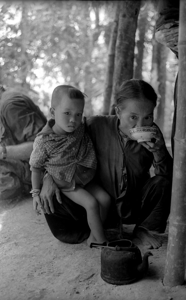 Old woman with kids drinks tea in Vietnam